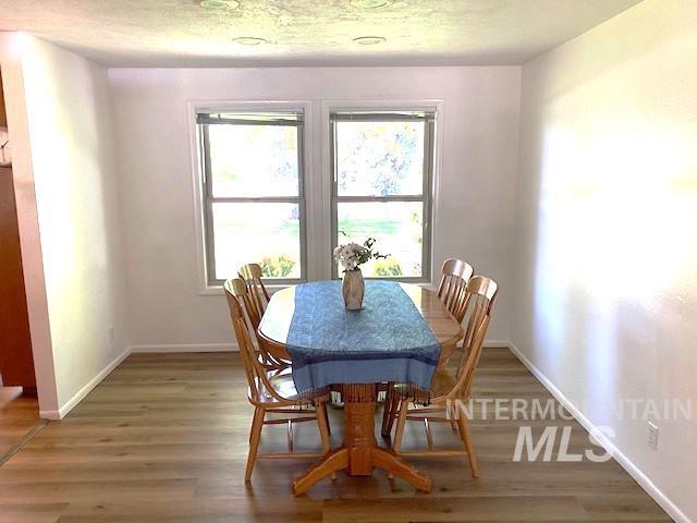 dining area featuring light wood-type flooring and baseboards