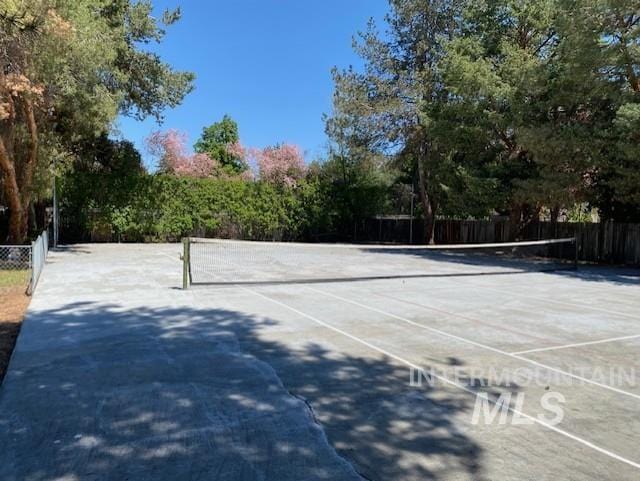 view of tennis court featuring fence