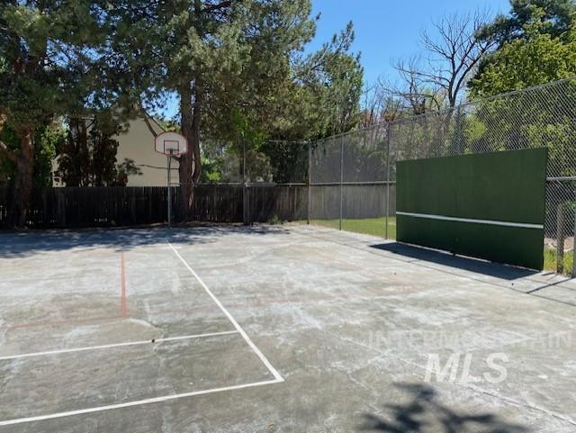 view of basketball court featuring basketball court and fence