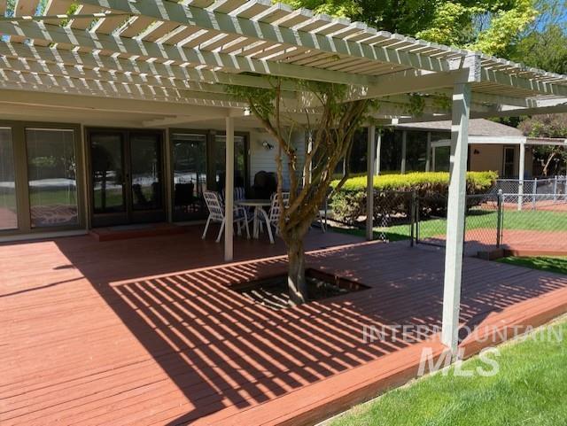 surrounding community featuring a deck, a pergola, and fence