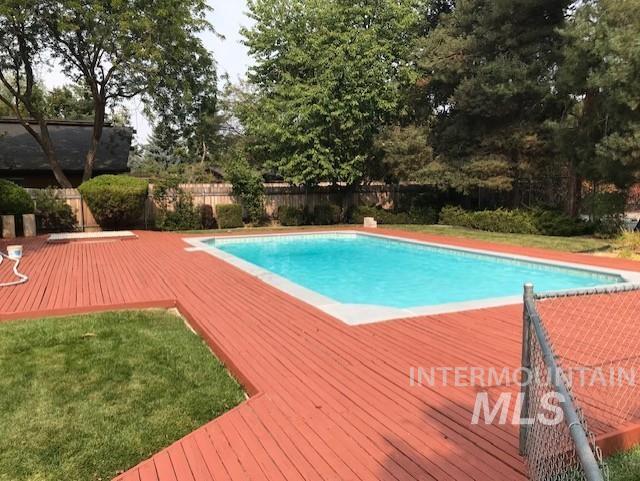 view of pool featuring fence and a wooden deck