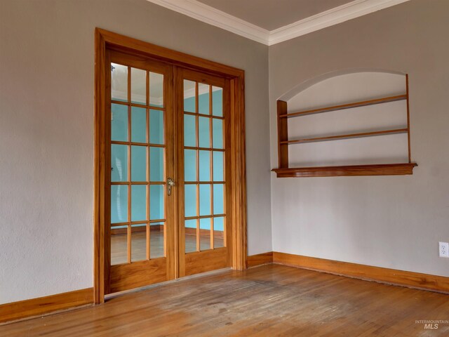 unfurnished room featuring french doors, ornamental molding, and hardwood / wood-style flooring