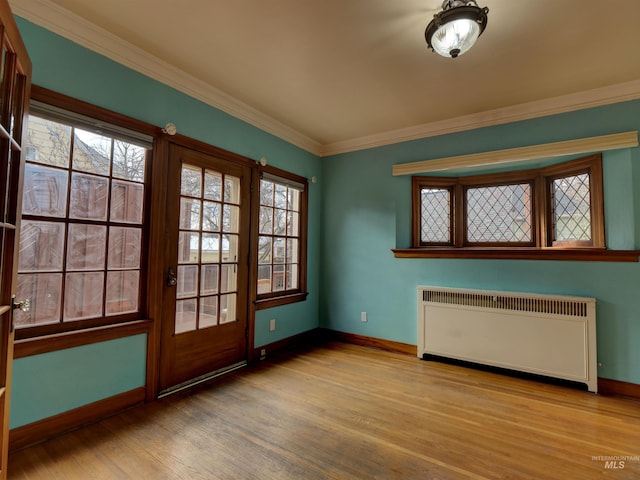 doorway with light hardwood / wood-style flooring, radiator heating unit, and ornamental molding