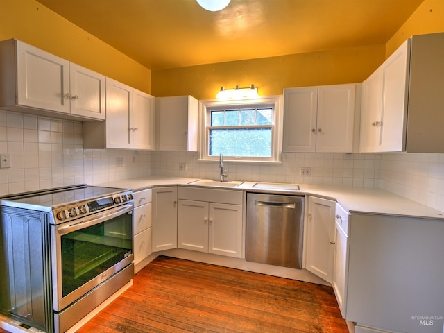 kitchen with white cabinetry, stainless steel appliances, sink, and backsplash