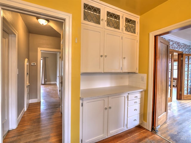 corridor with crown molding and dark hardwood / wood-style flooring