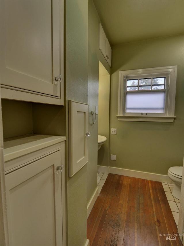 bathroom featuring wood-type flooring and toilet