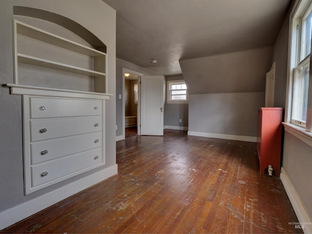 bonus room featuring lofted ceiling, dark hardwood / wood-style flooring, and built in features