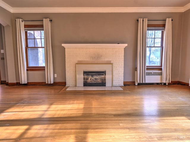 unfurnished living room with ornamental molding and light hardwood / wood-style floors