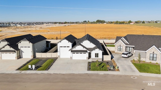 view of front of home featuring fence, an attached garage, and driveway