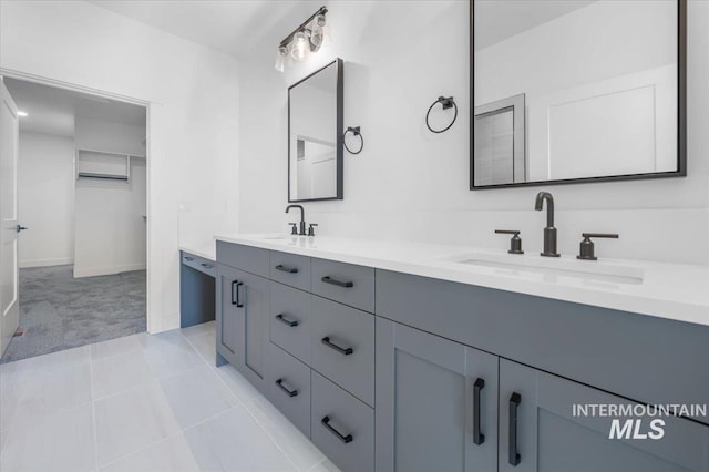 full bath with baseboards, a sink, and double vanity
