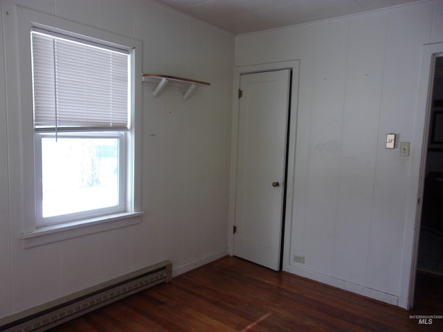 spare room featuring baseboard heating and wood finished floors