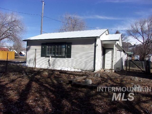 view of property exterior featuring metal roof and fence