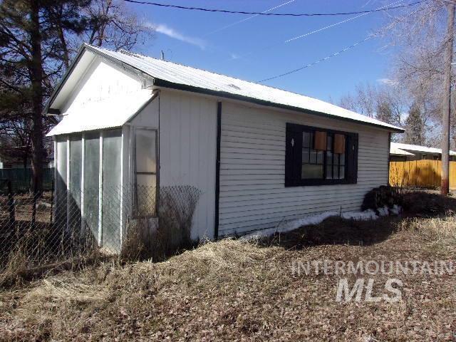 view of property exterior with metal roof and fence