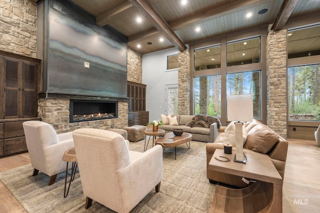 1010 Elo Rd, Mccall, ID 83638 - living room with a wooden ceiling with exposed beams, wood finished floors, a stone fireplace, a towering ceiling, and recessed lighting