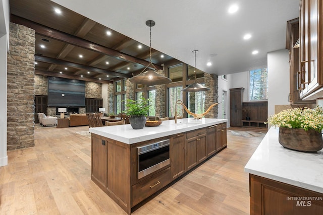 1010 Elo Rd, Mccall, ID 83638 - kitchen with an island with sink, light wood finished floors, beam ceiling, decorative light fixtures, and open floor plan