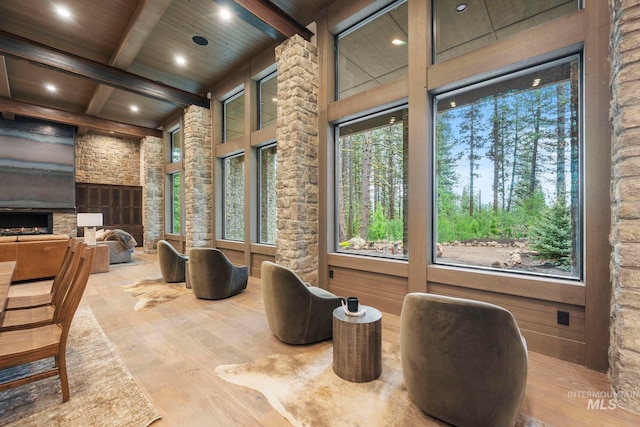 1010 Elo Rd, Mccall, ID 83638 - interior space featuring a wood ceiling with exposed beams, wood finished floors, recessed lighting, a warm lit fireplace, and healthy amount of natural light