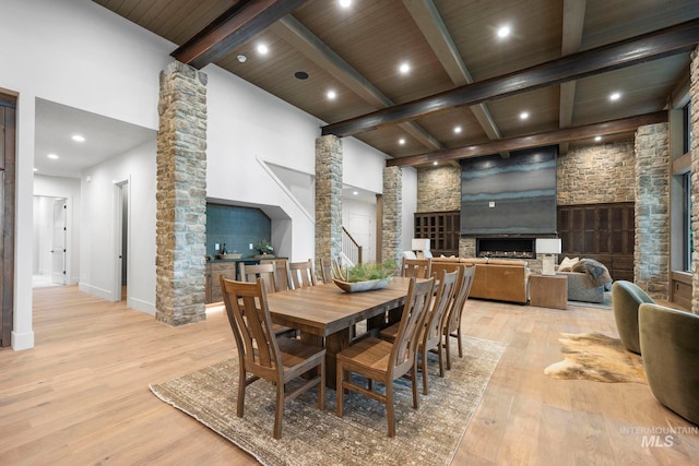 1010 Elo Rd, Mccall, ID 83638 - dining area with a fireplace, light wood-style flooring, a wooden ceiling with exposed beams, ornate columns, and recessed lighting