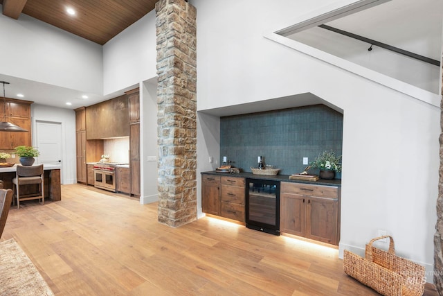 1010 Elo Rd, Mccall, ID 83638 - indoor dry bar featuring wine cooler, range with two ovens, light wood finished floors, decorative backsplash, and recessed lighting