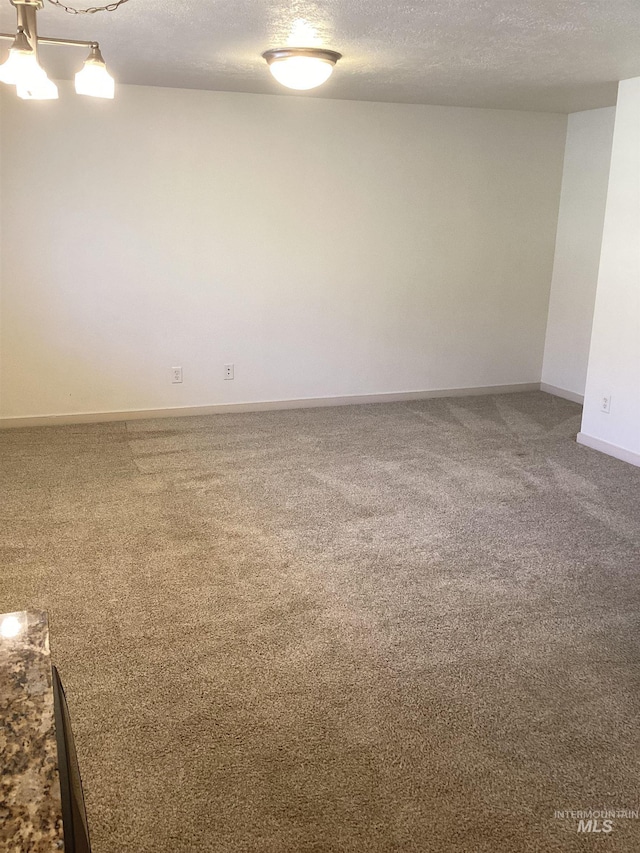 carpeted empty room with a textured ceiling