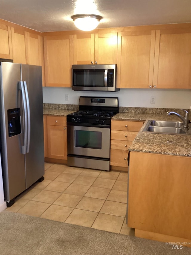 kitchen with light tile patterned floors, stainless steel appliances, sink, and light brown cabinets