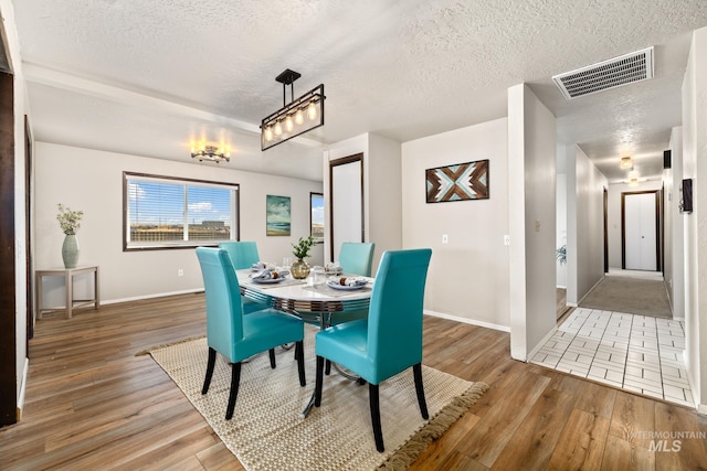 dining room with a textured ceiling and hardwood / wood-style flooring