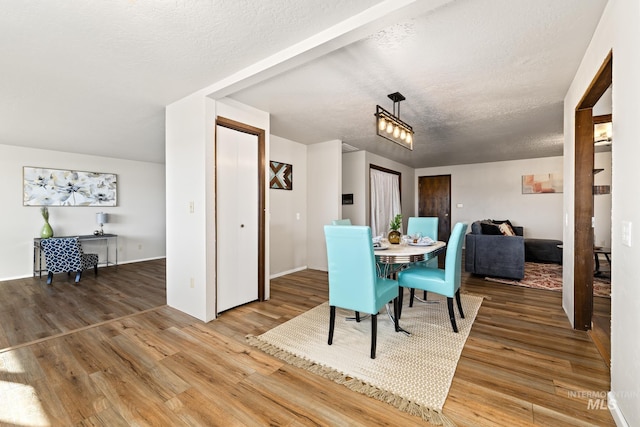 dining room with a textured ceiling and hardwood / wood-style flooring