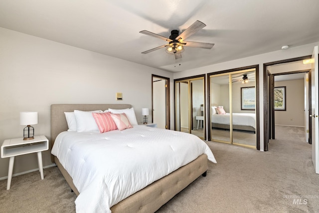 carpeted bedroom with two closets and ceiling fan