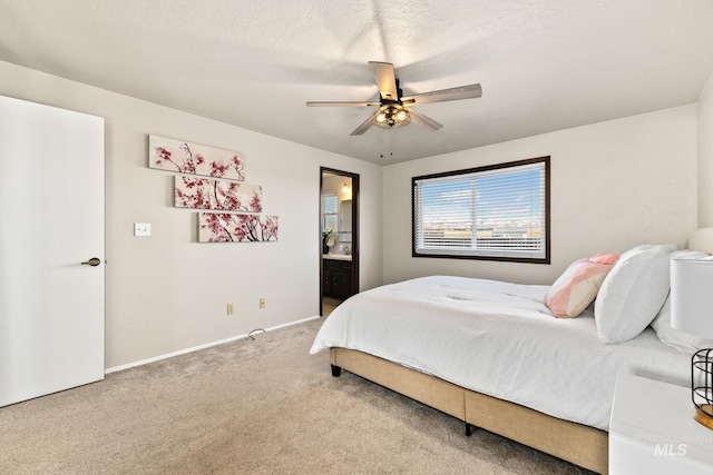 bedroom with connected bathroom, ceiling fan, carpet floors, and a textured ceiling