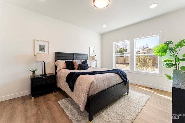 bedroom featuring baseboards, visible vents, wood finished floors, and recessed lighting