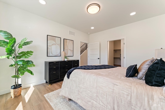 bedroom with light wood-type flooring, visible vents, baseboards, and recessed lighting