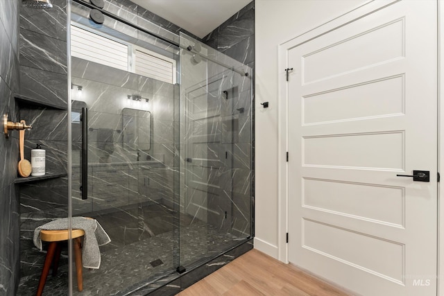 full bathroom featuring wood finished floors and a marble finish shower