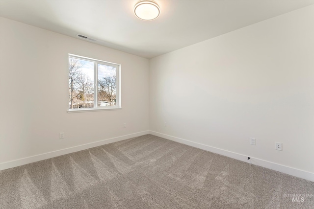 carpeted empty room featuring baseboards and visible vents