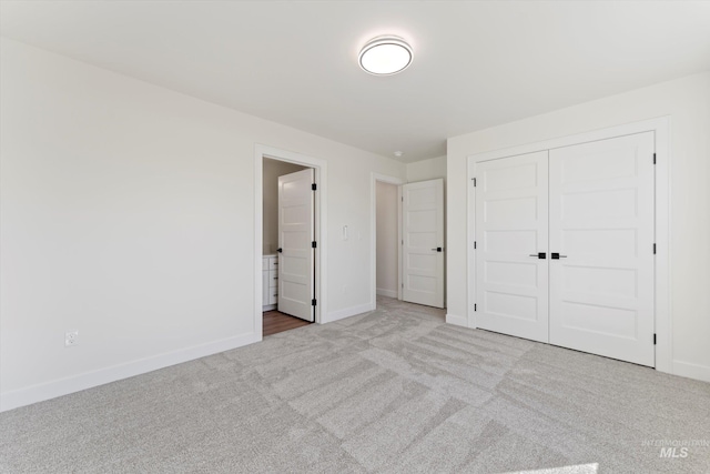 unfurnished bedroom featuring carpet, baseboards, and a closet