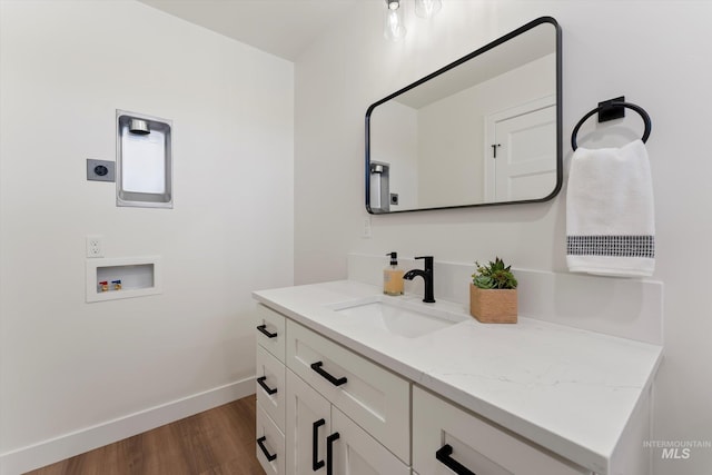 bathroom with vanity, baseboards, and wood finished floors