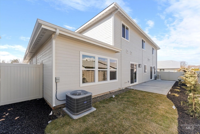 back of property with a yard, a fenced backyard, a patio, and central AC unit