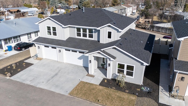 view of front of home featuring a garage, driveway, a residential view, roof with shingles, and board and batten siding