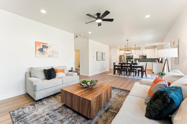 living area featuring light wood-type flooring, baseboards, and recessed lighting