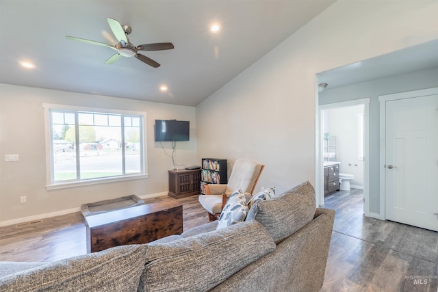 living area featuring baseboards, ceiling fan, wood finished floors, and vaulted ceiling