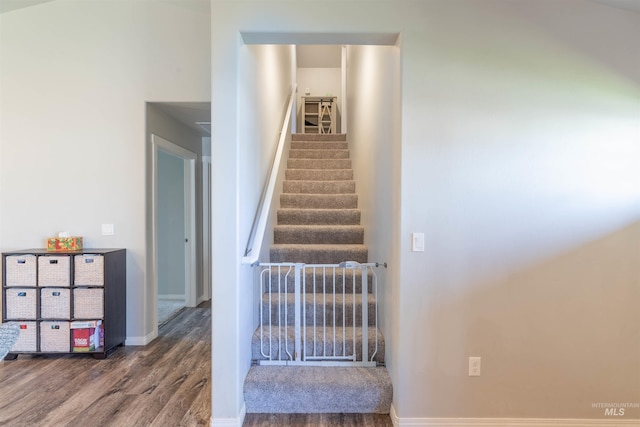 staircase with baseboards and wood finished floors