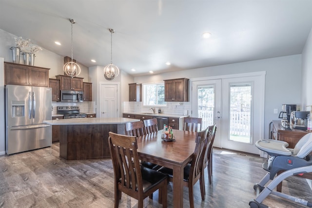 dining area featuring vaulted ceiling, french doors, recessed lighting, and wood finished floors