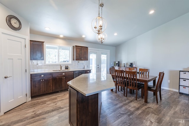 kitchen with french doors, a sink, wood finished floors, and dark brown cabinets