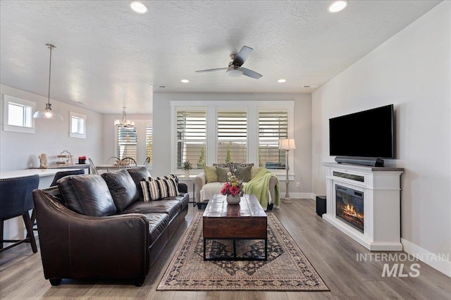 300 S Adventure Way, Kuna, ID 83634 - living room with ceiling fan, a chandelier, wood finished floors, baseboards, and recessed lighting