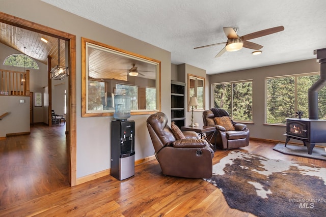 16 Meadow Ln, Boise, ID 83716 - living area featuring ceiling fan, a wood stove, wood finished floors, lofted ceiling, and a textured ceiling
