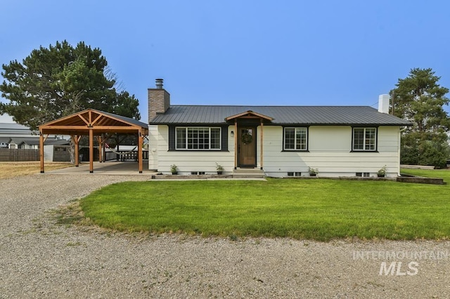 ranch-style house featuring a chimney, a front lawn, driveway, and metal roof