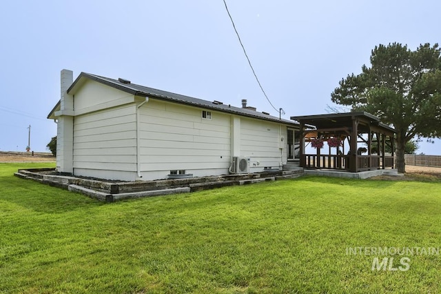 back of house with a chimney, ac unit, and a yard