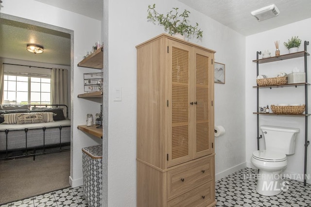 bathroom with visible vents, tile patterned floors, baseboards, and toilet