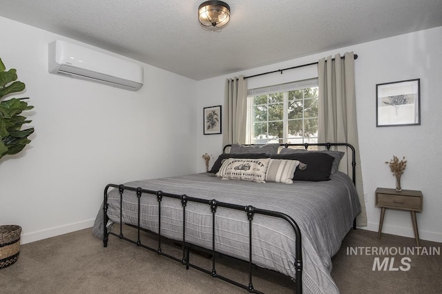 bedroom featuring carpet floors, a textured ceiling, a wall mounted AC, and baseboards