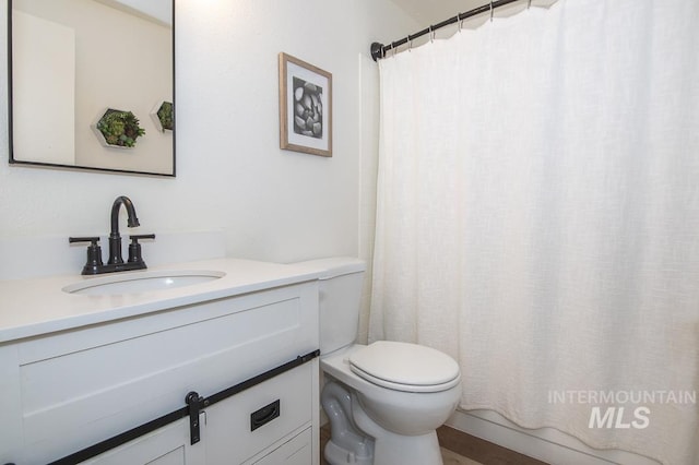 bathroom with vanity, curtained shower, and toilet