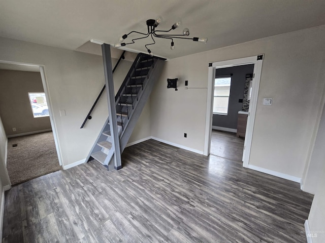 unfurnished living room featuring stairway, wood finished floors, and baseboards