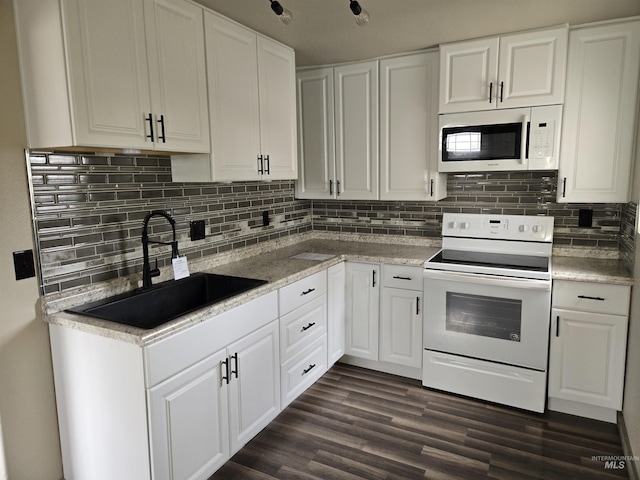 kitchen featuring white appliances, white cabinets, and a sink